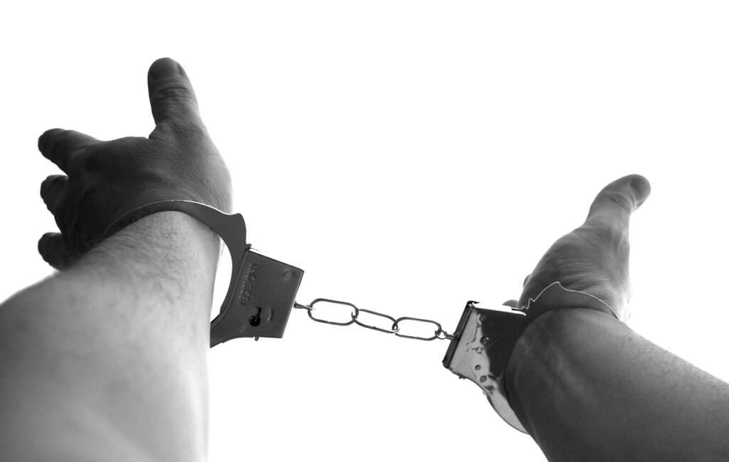Hands with handcuff - The Guide to Criminal Justice System